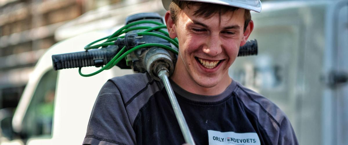 Een bouwplaatsmedewerker bouwvakker van Orly & Endevoets in werkkleding met een lach op zijn gezicht en dat vertelt wat over ons