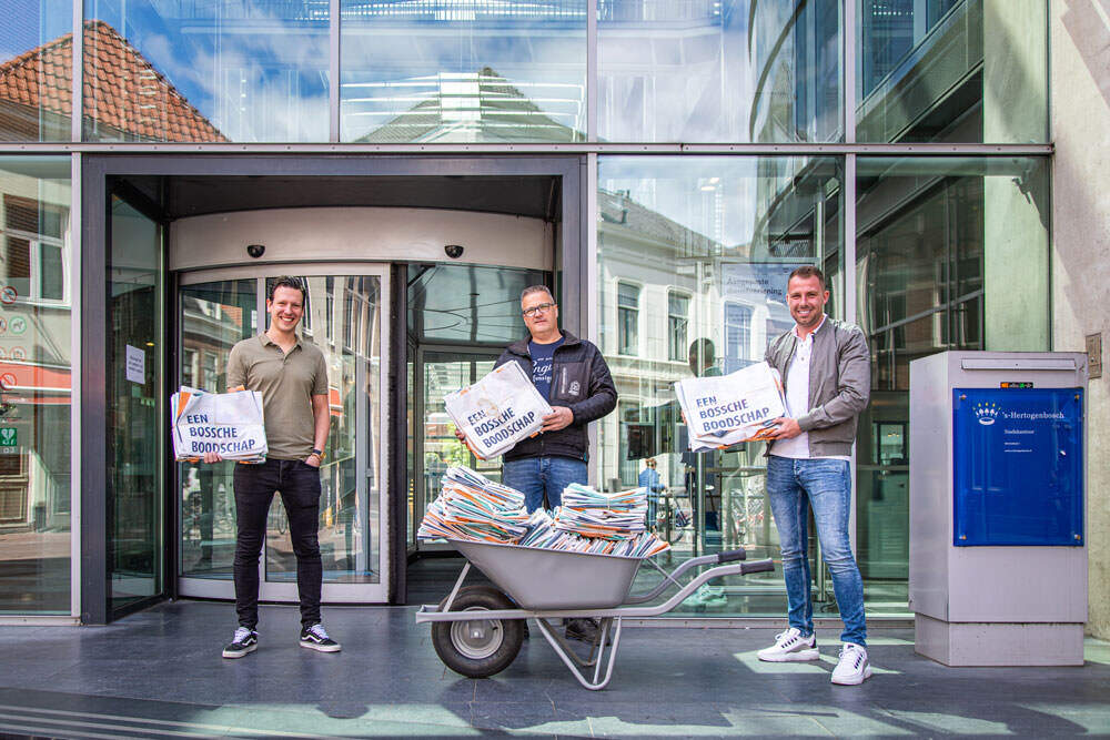 Een werknemer van familiebedrijf Orly & Endevoets samen met twee mannen van de gemeente 's-Hertogenbosch. Zij overhandigen elkaar een door Orly & Endevoets duurzame en circulair gemaakte tas.