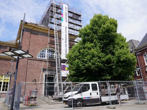 Steiger voor de Grote Kerk in 's-Hertogenbosch met aan de steiger steigerdoeken bevestigd