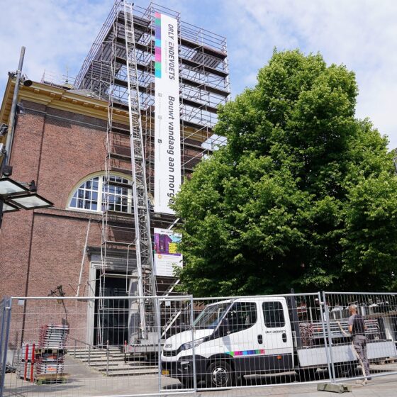 Steiger voor de Grote Kerk in 's-Hertogenbosch met aan de steiger steigerdoeken bevestigd